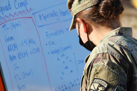 Cadet writes on a whiteboard.